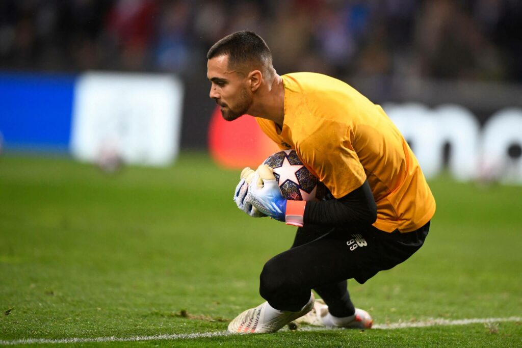 Diogo Costa reçoit un ballon dans le but et l'embrasse avec les mains. 