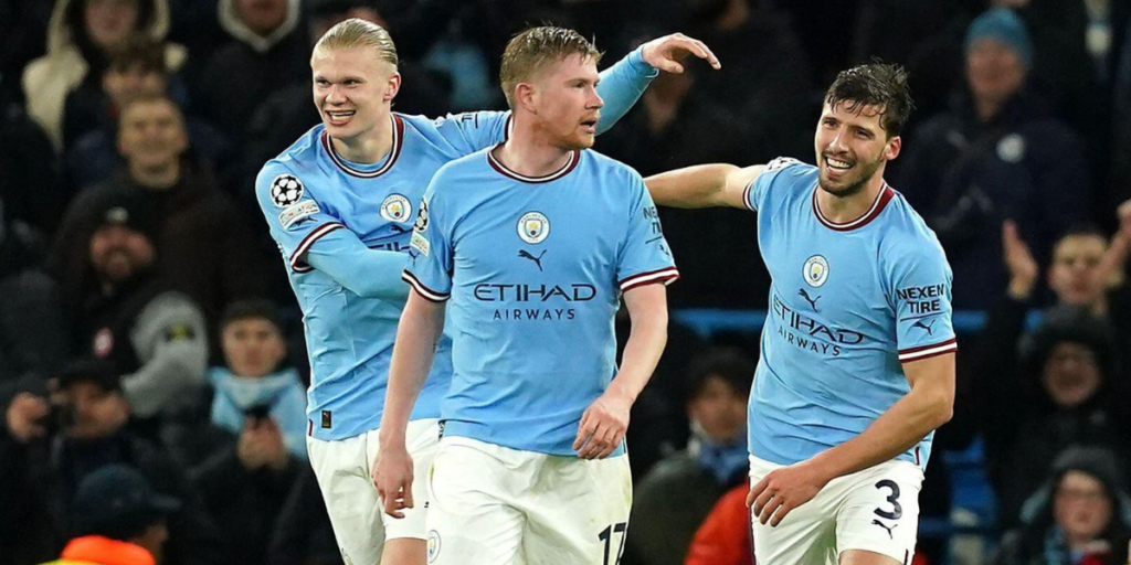 Erling Haaland célébrant avec Kevin De Bruyne et Rúben Dias après avoir marqué un but.